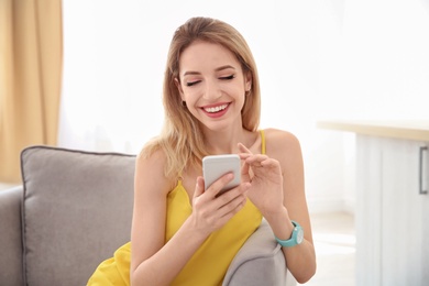 Young woman using phone indoors