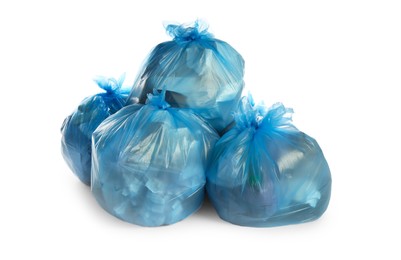 Blue trash bags filled with garbage on white background