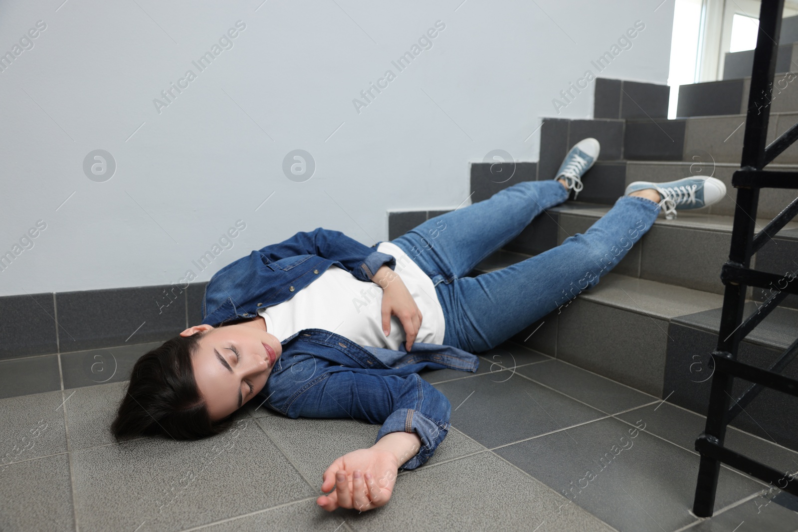 Photo of Unconscious woman lying on floor after falling down stairs indoors