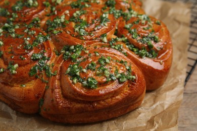 Photo of Traditional Ukrainian garlic bread with herbs (Pampushky) on table, closeup