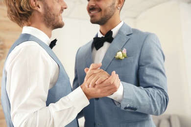 Photo of Newlywed gay couple dancing at home, closeup