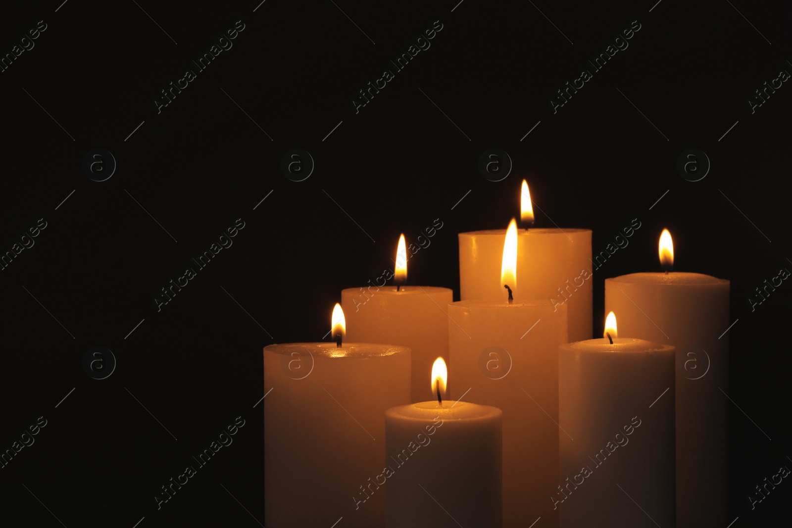 Photo of Burning candles on dark background, space for text. Symbol of sorrow