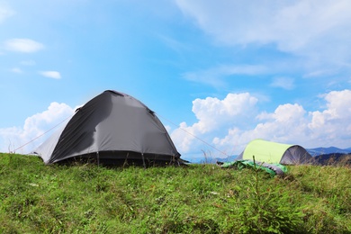 Photo of Small camping tents in mountains on sunny day