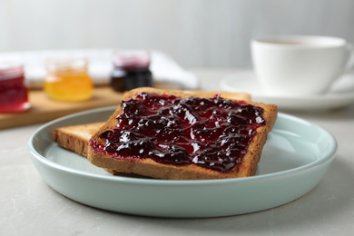 Photo of Delicious crispy toasts with jam on table