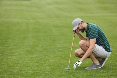 Photo of Man playing golf on green course. Space for text