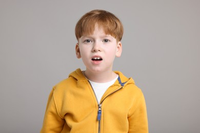 Photo of Portrait of surprised little boy on grey background