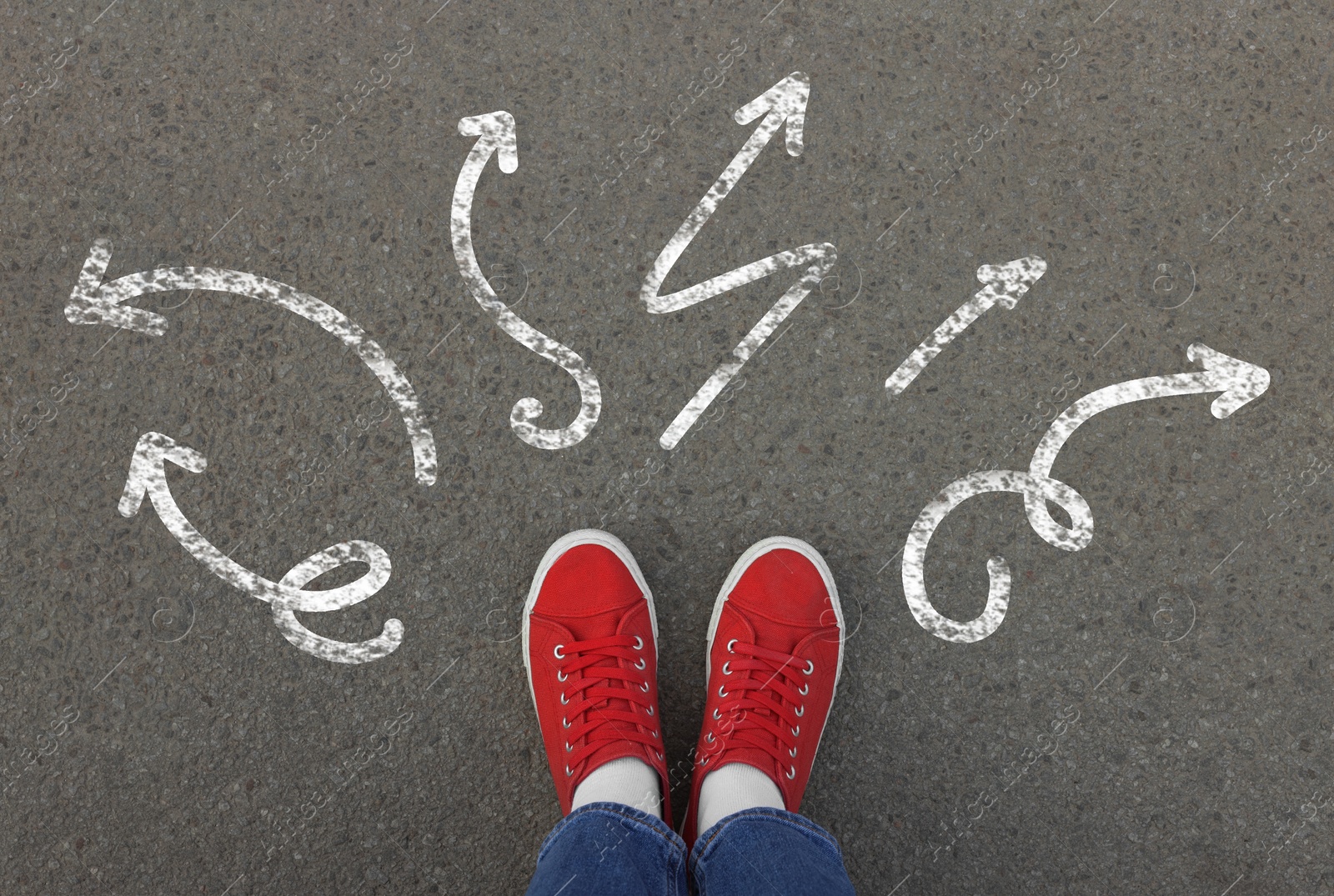 Image of Choosing future profession. Girl standing in front of drawn signs on asphalt, top view. Arrows pointing in different directions symbolizing diversity of opportunities