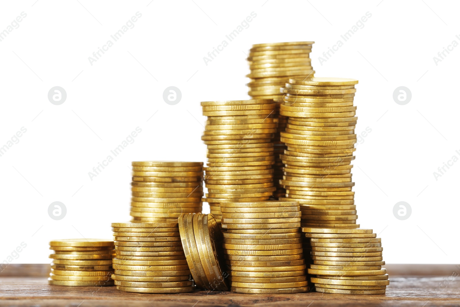 Photo of Stack of coins on wooden table, closeup