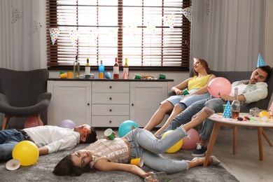 Photo of Group of friends sleeping in messy room after party