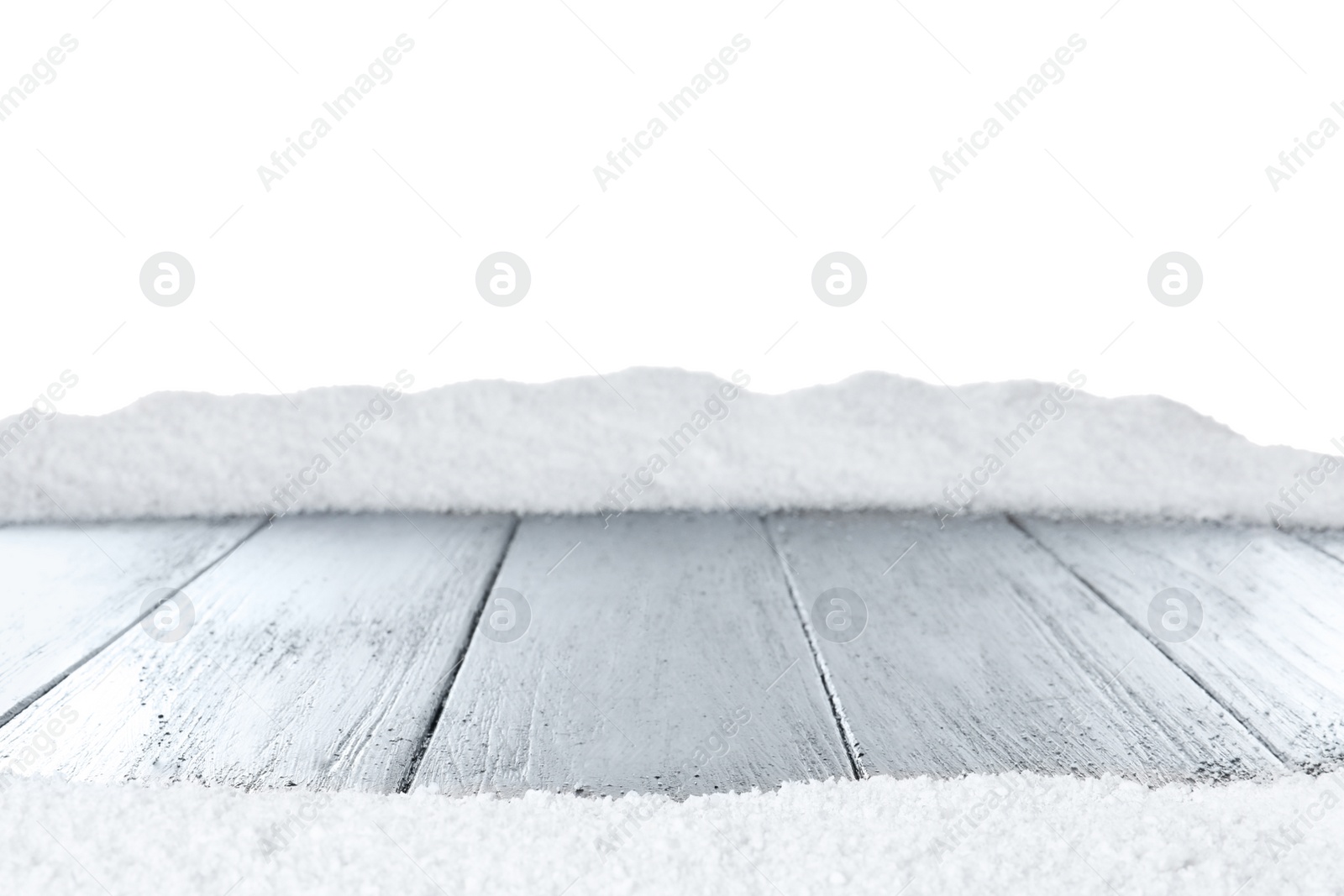 Photo of Heap of snow on grey wooden surface against white background