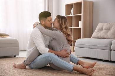 Photo of Lovely couple enjoying time together on floor in living room