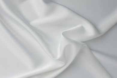 Photo of Texture of crumpled white silk fabric as background, top view