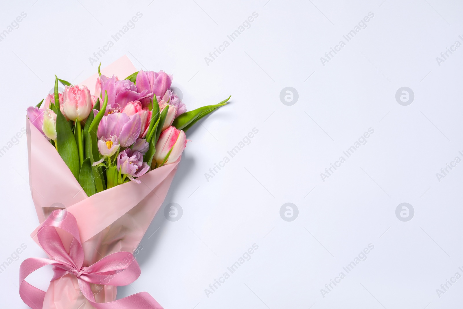 Photo of Beautiful bouquet of colorful tulip flowers on white background, top view. Space for text