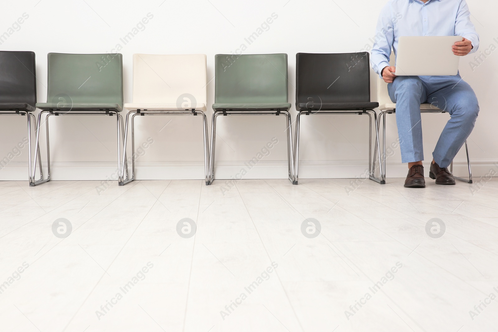 Photo of Young man sitting on chair and waiting for job interview