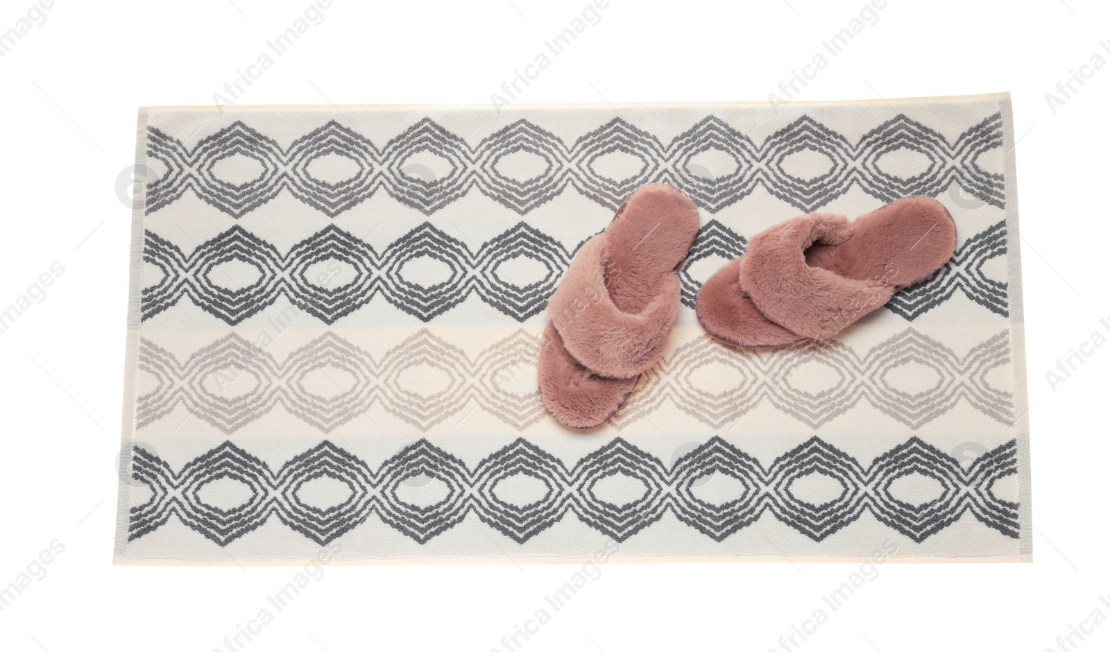 Photo of Soft bath mat and slippers isolated on white, top view