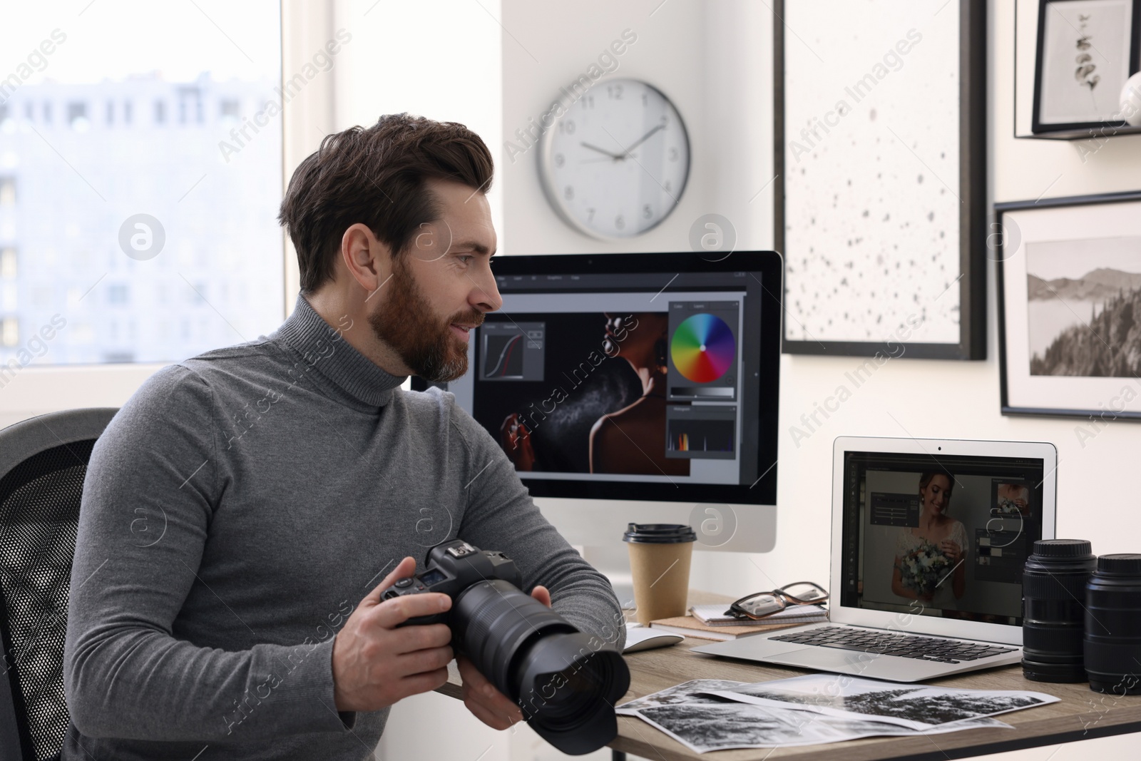 Photo of Professional photographer with digital camera at table in office