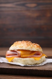 Photo of Delicious bagel with ham and cheese on table. Space for text