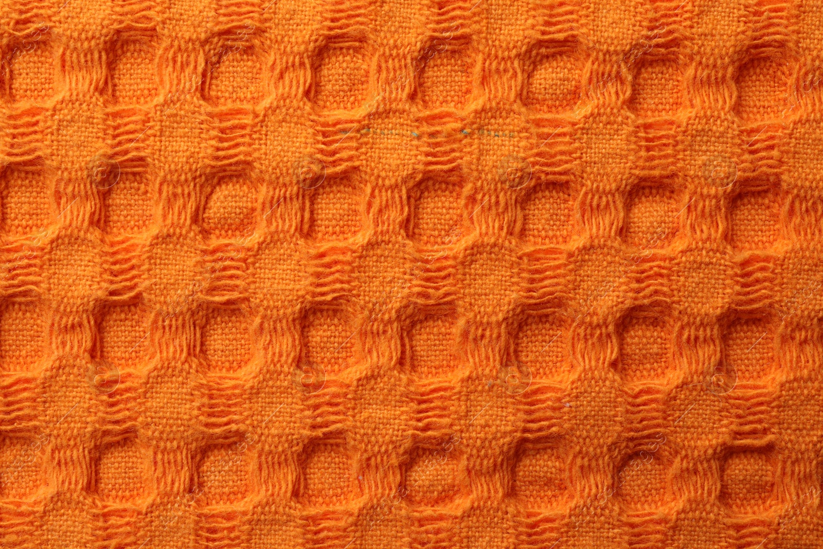Photo of Texture of orange knitted fabric as background, top view