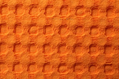 Photo of Texture of orange knitted fabric as background, top view