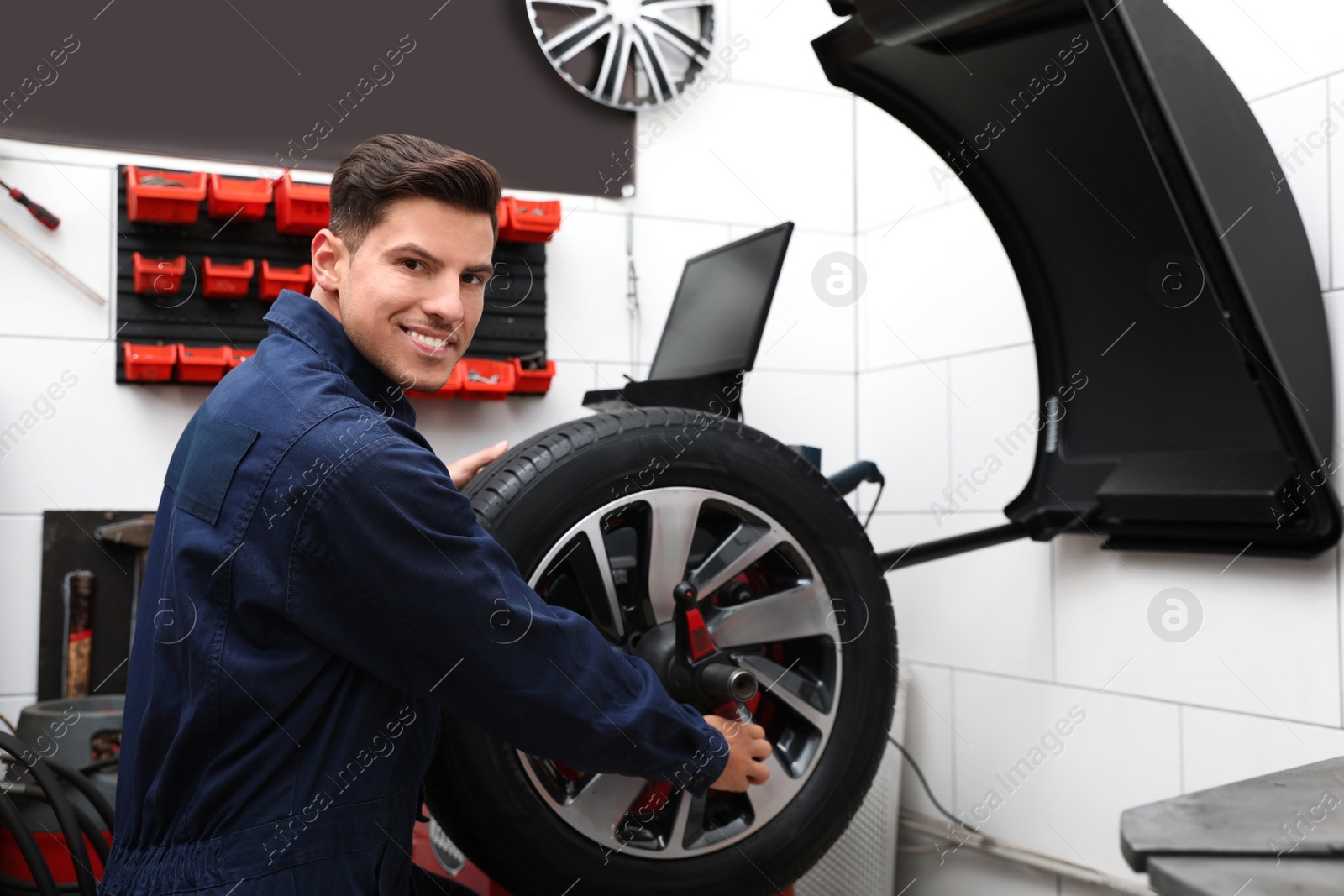 Photo of Man working with wheel balancing machine at tire service