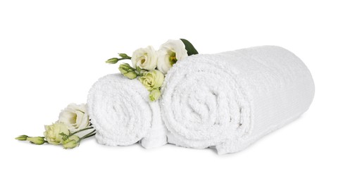Photo of Clean soft towels with flowers isolated on white