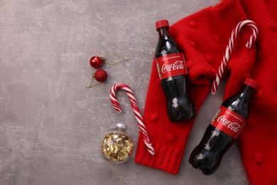 Photo of MYKOLAIV, UKRAINE - JANUARY 13, 2021: Flat lay composition with Coca-Cola bottles, Christmas decor and red sweater on floor