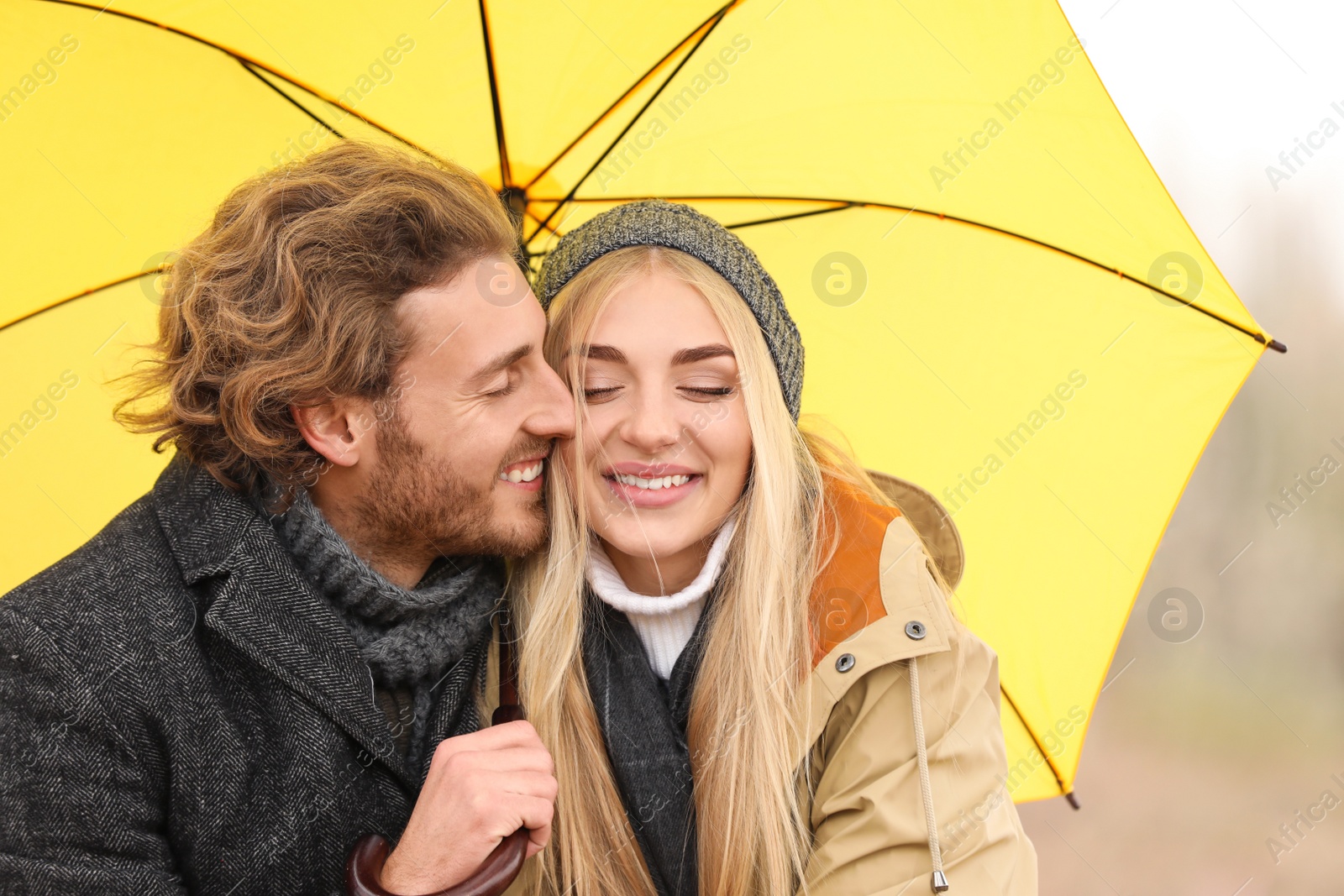 Photo of Young romantic couple with umbrella outdoors on autumn day