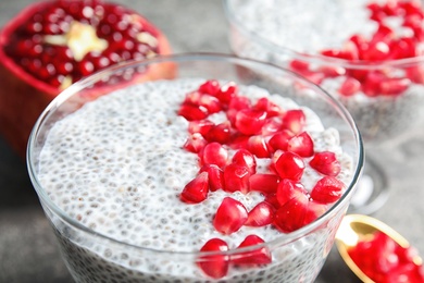 Tasty chia seed pudding with pomegranate in dessert bowl on table, closeup