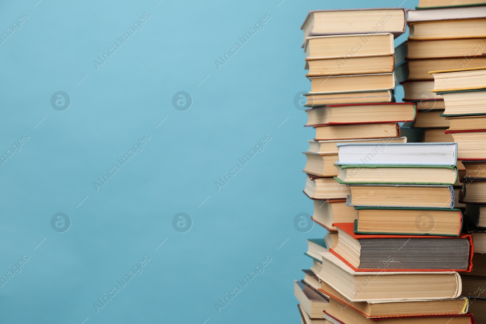 Photo of Many hardcover books on turquoise background, space for text. Library material