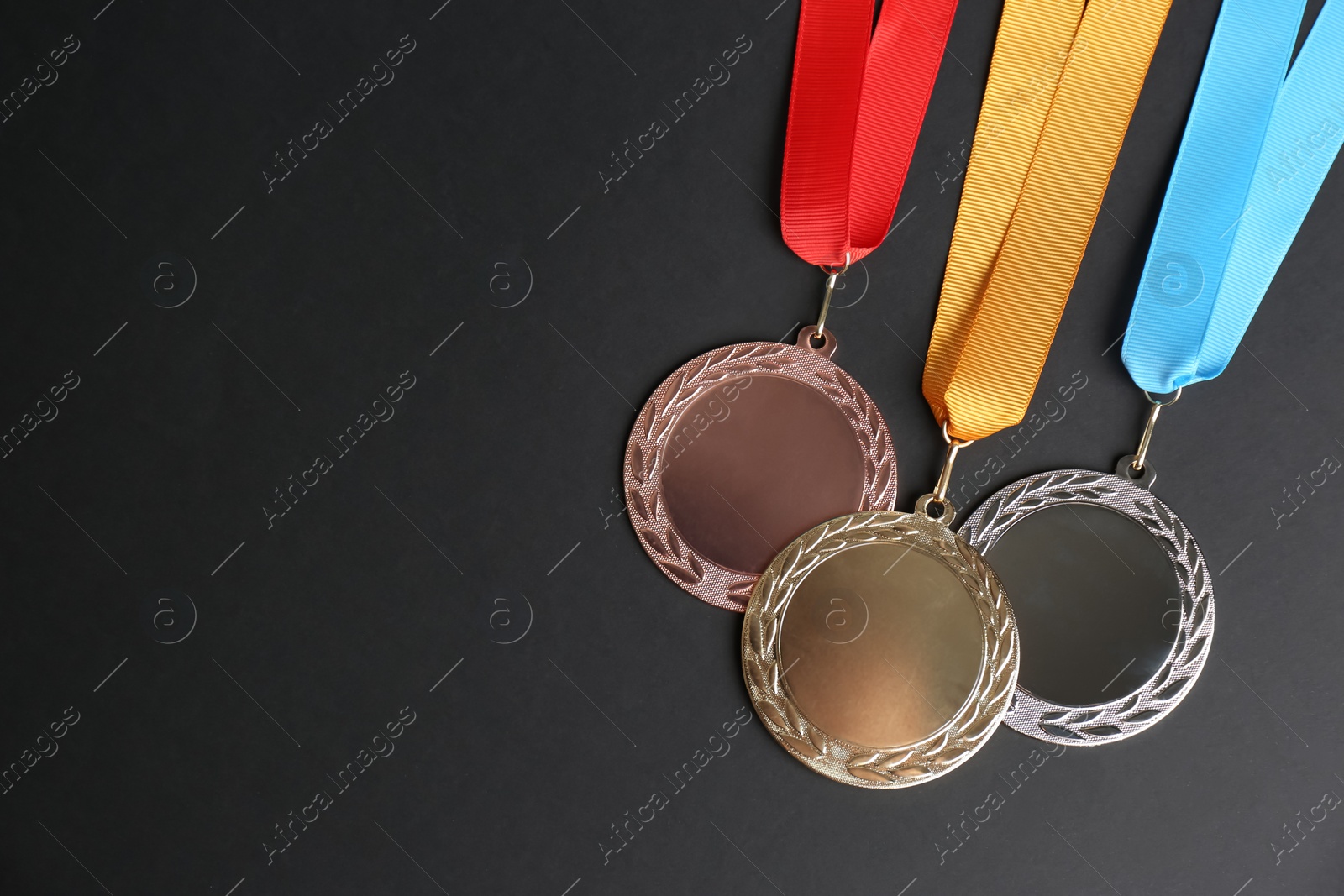 Photo of Gold, silver and bronze medals on black background, flat lay. Space for design