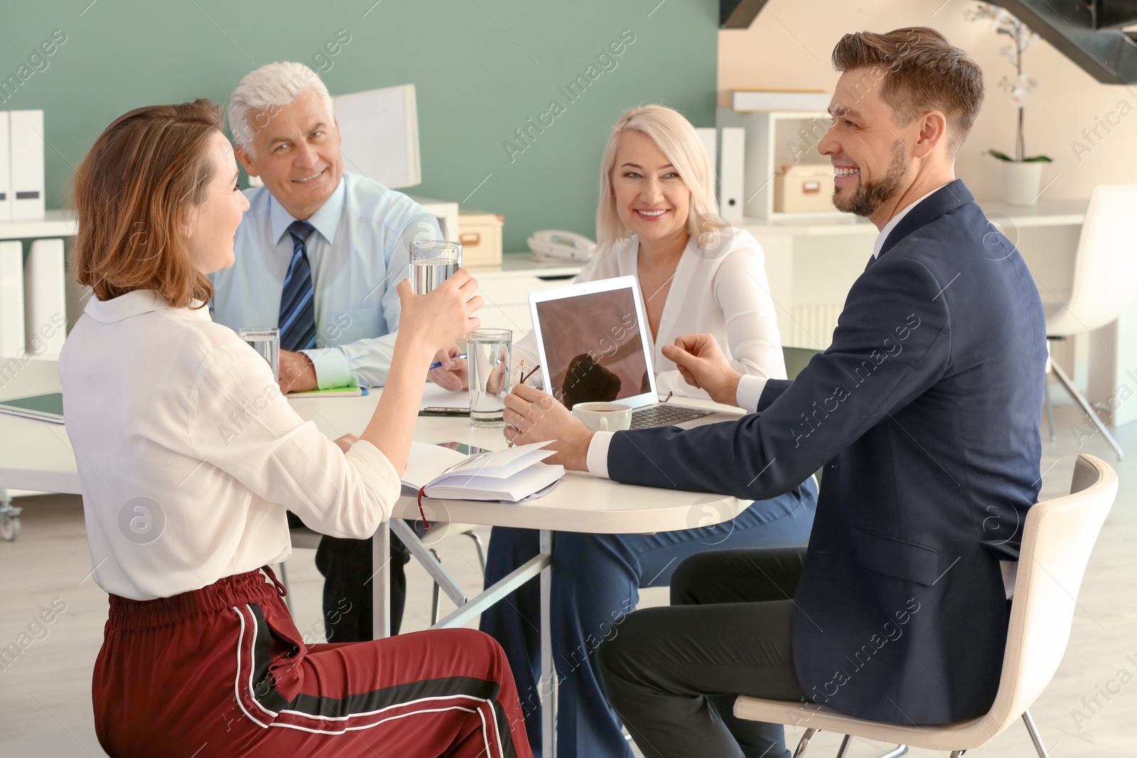 Photo of Group of people discussing ideas at table in office. Consulting service concept