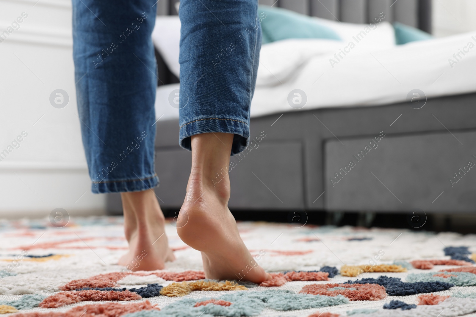 Photo of Woman walking on carpet with pattern at home, closeup. Space for text