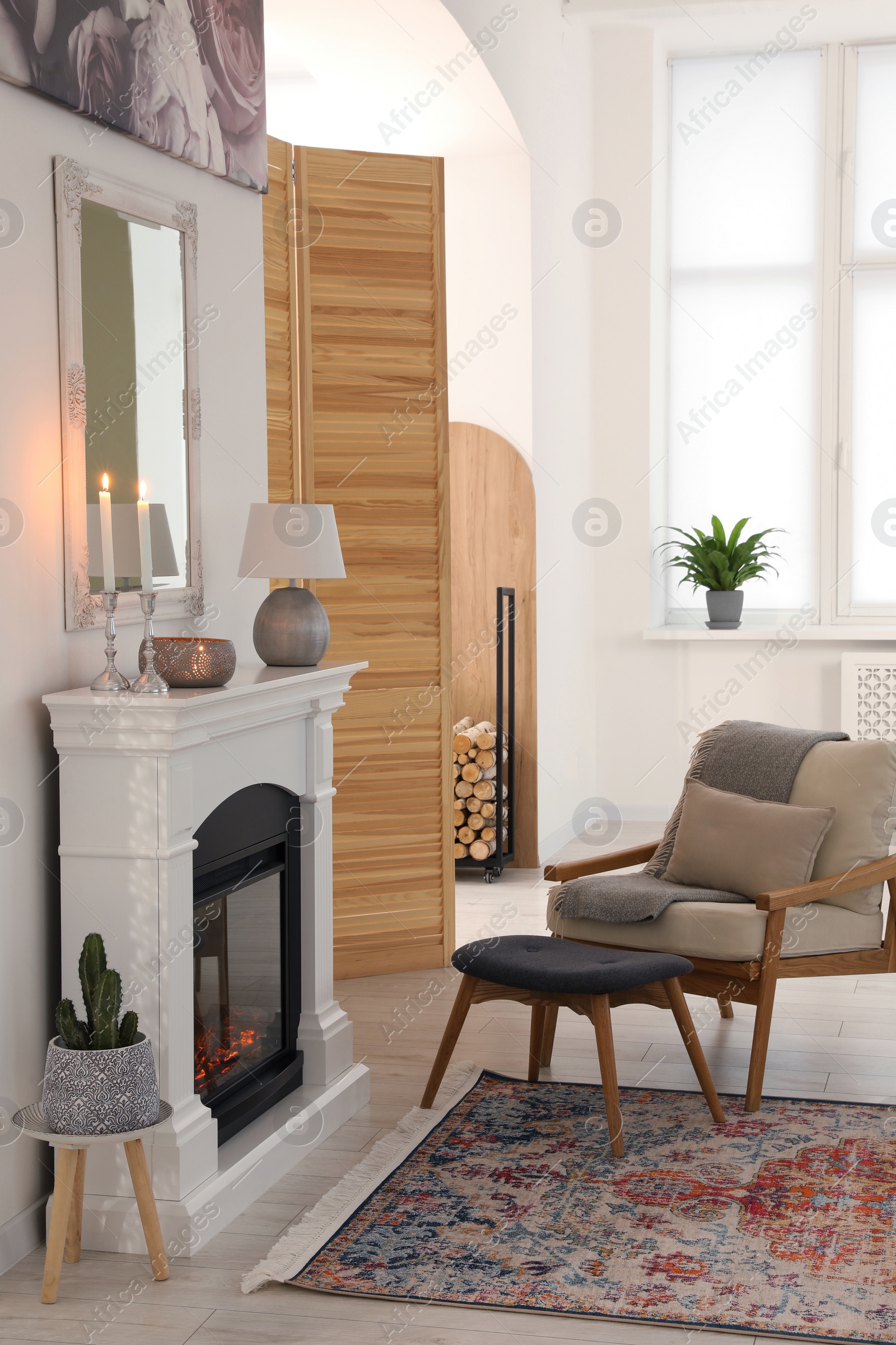 Photo of Stylish living room with beautiful fireplace, armchair and ottoman. Interior design