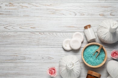 Photo of Flat lay composition of herbal bags and spa products on white wooden table, space for text