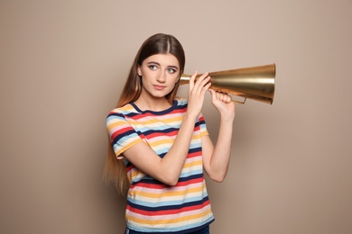 Photo of Young woman with megaphone on color background