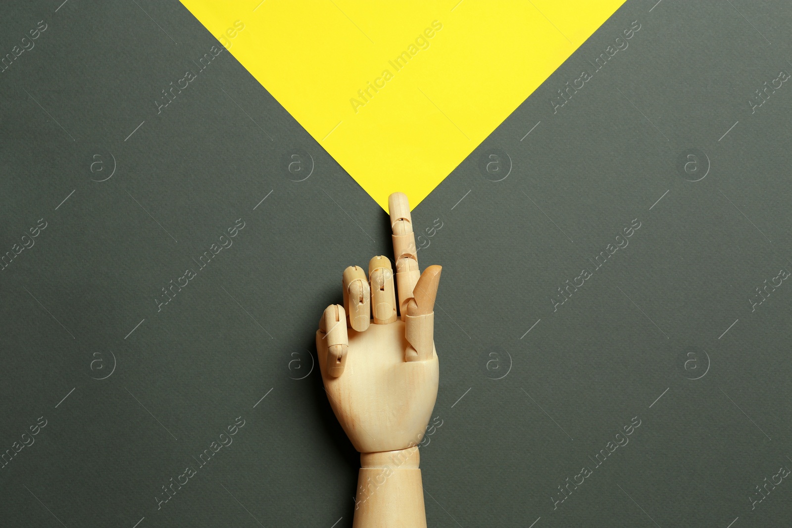 Photo of Wooden mannequin hand on color background, top view