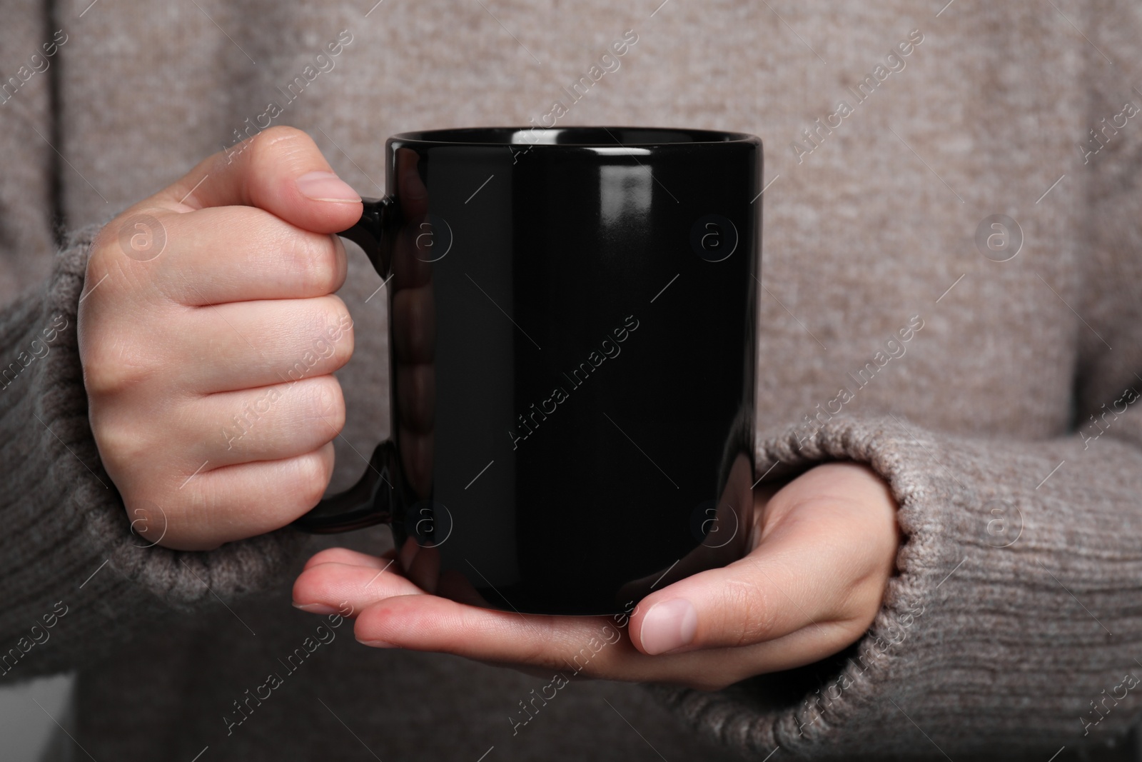 Photo of Woman holding black mug of drink, closeup