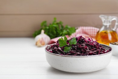 Photo of Tasty red cabbage sauerkraut with parsley on white wooden table. Space for text