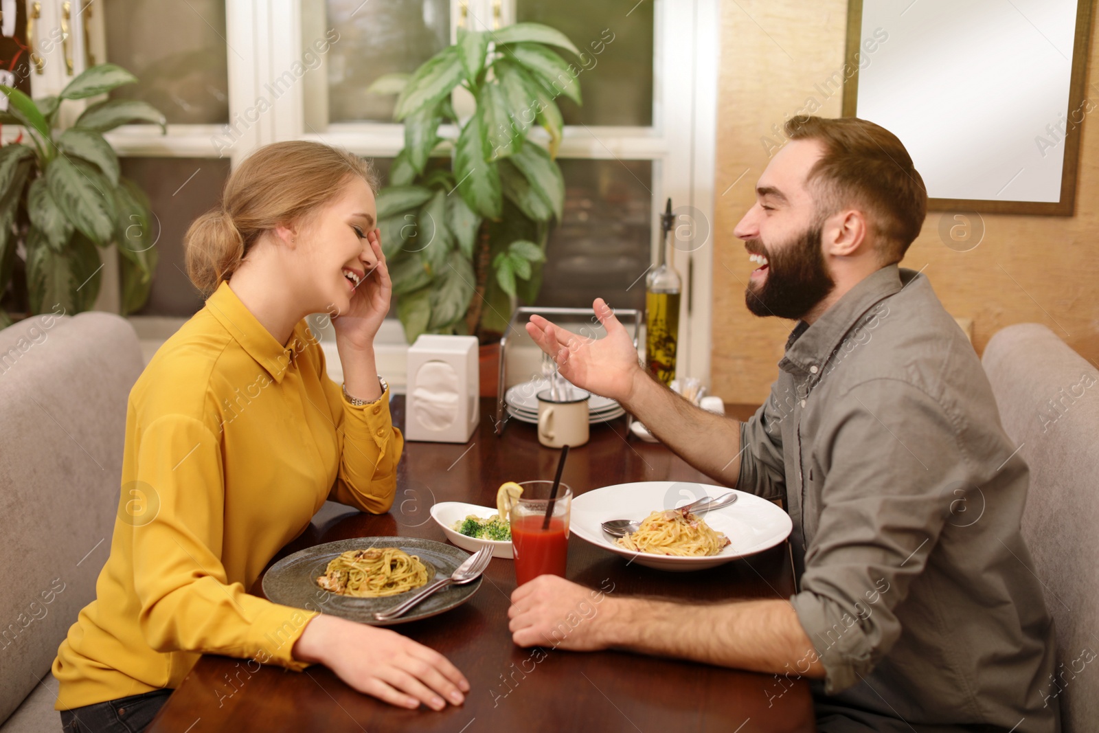Photo of Lovely young couple having pasta carbonara for dinner at restaurant