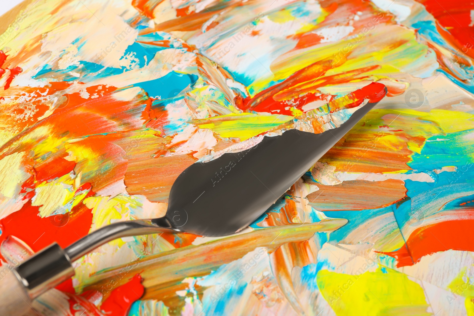 Photo of Closeup view of dirty artist's palette with painting knife as background