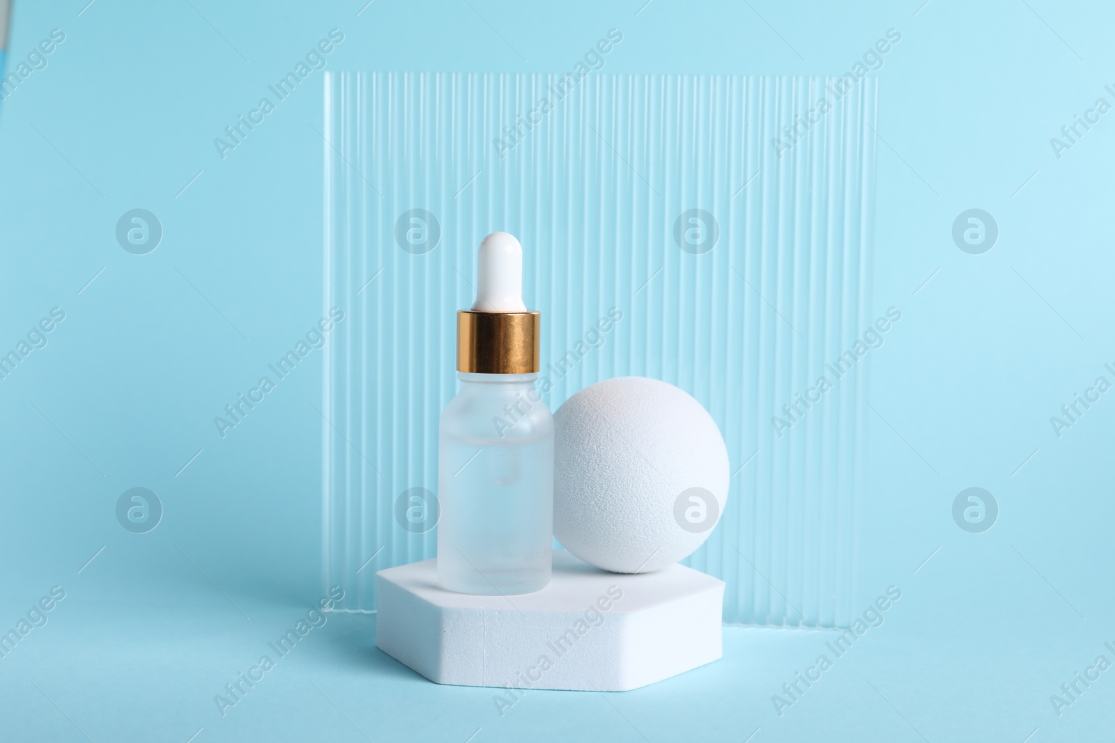 Photo of Stylish presentation of cosmetic serum on light blue background