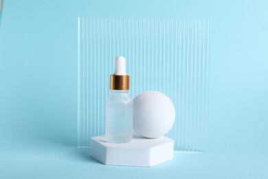 Photo of Stylish presentation of cosmetic serum on light blue background