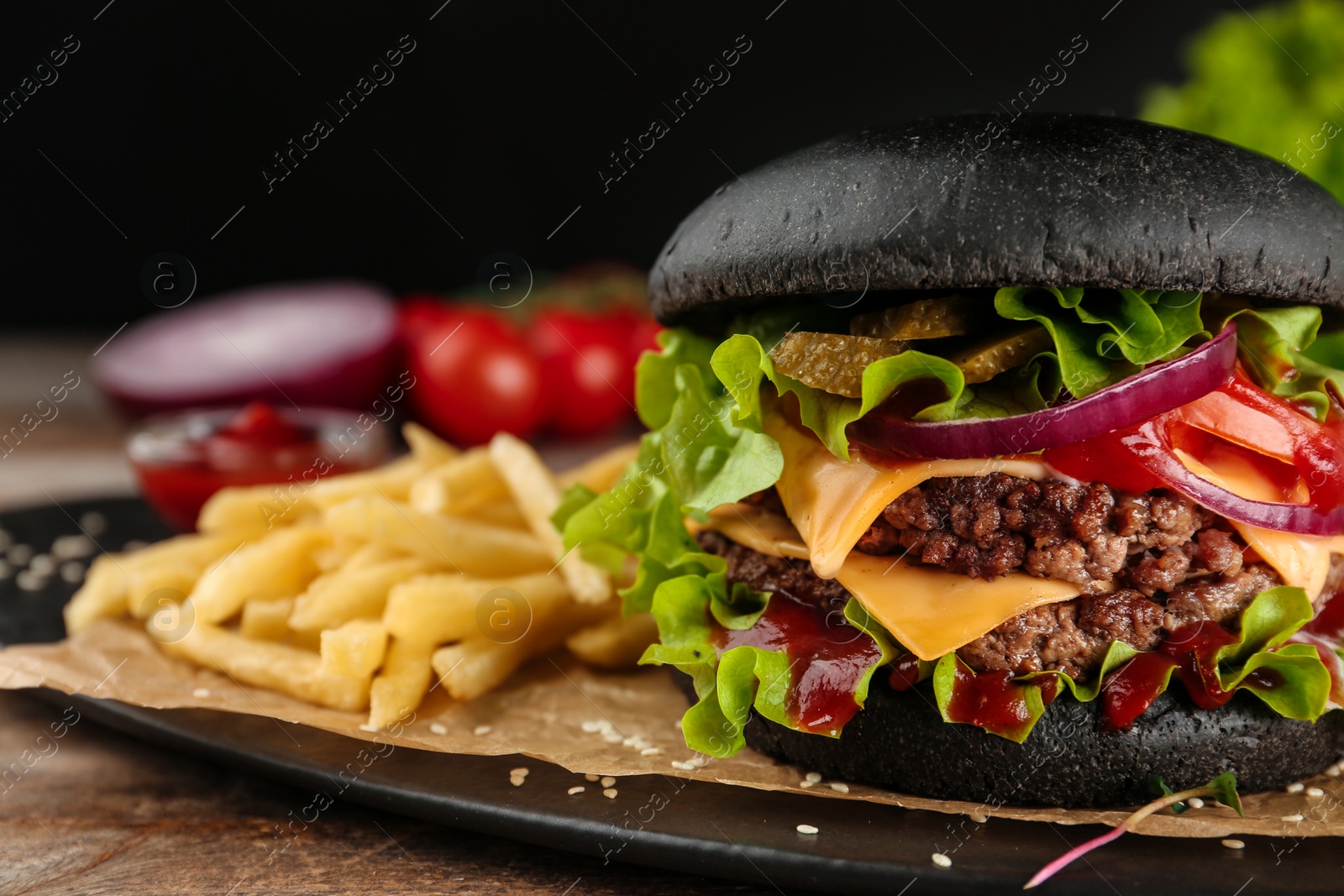 Photo of Plate with black burger and French fries on table, closeup. Space for text