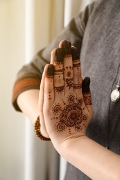 Photo of Woman with henna tattoo on hand, closeup. Traditional mehndi ornament