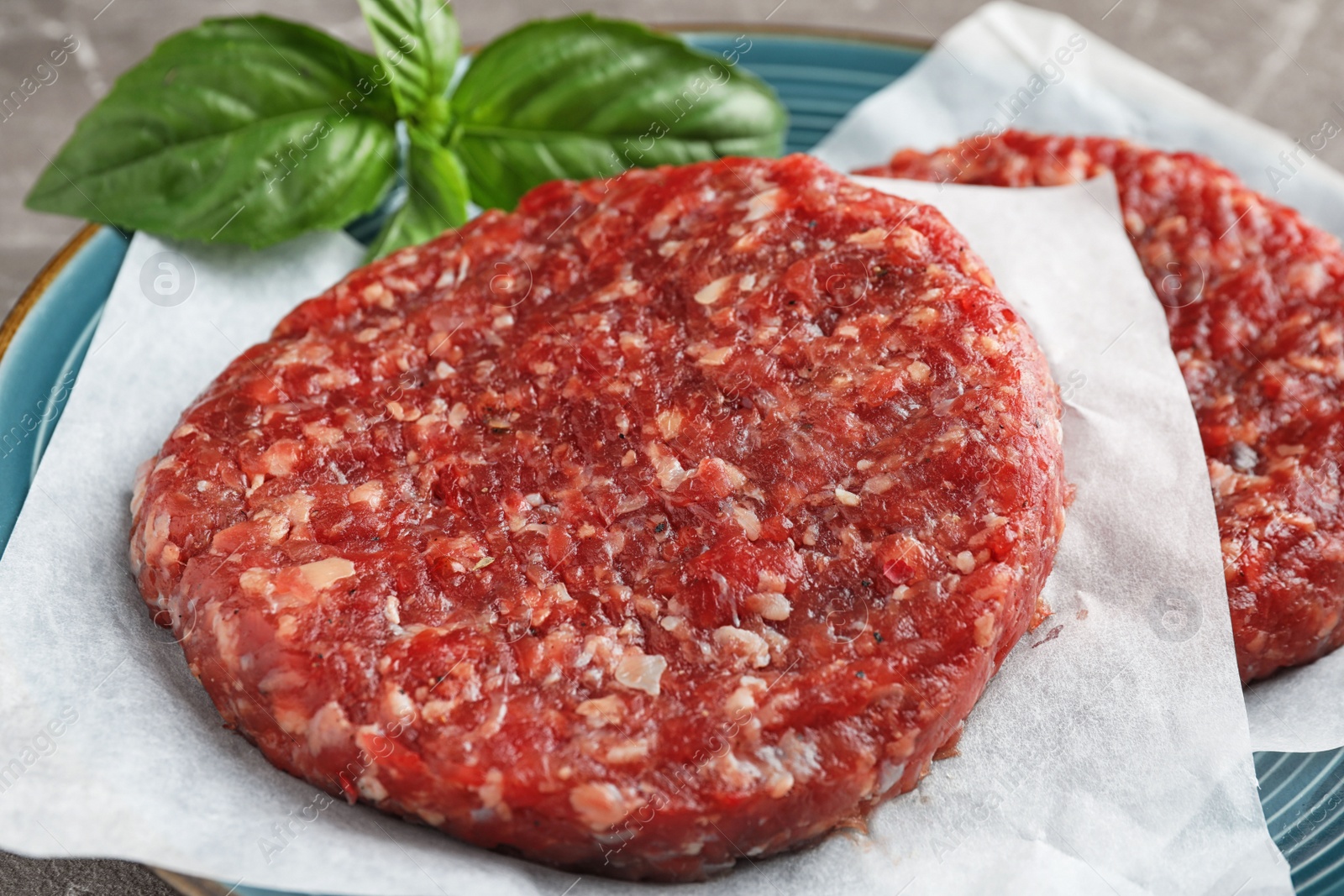 Photo of Raw meat cutlets for burger on plate, closeup