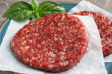 Photo of Raw meat cutlets for burger on plate, closeup