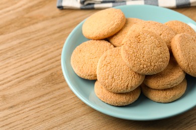 Photo of Delicious sugar cookies on wooden table, closeup. Space for text