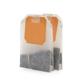 Photo of New tea bags with tabs on white background