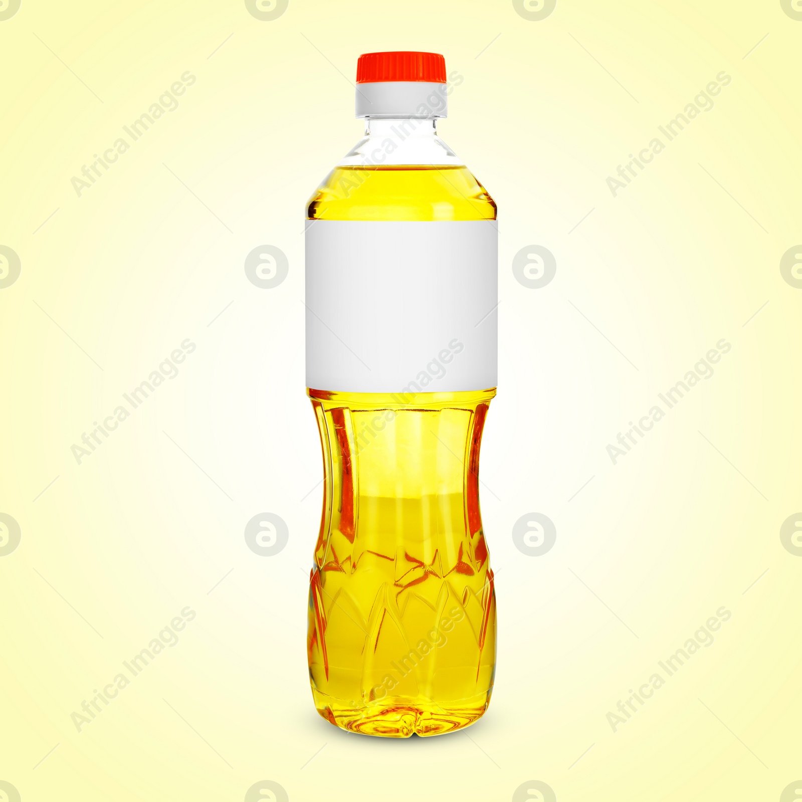 Image of Cooking oil in plastic bottle with empty label on light yellow background. Mockup for design