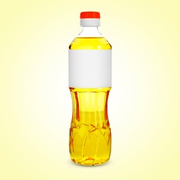 Image of Cooking oil in plastic bottle with empty label on light yellow background. Mockup for design